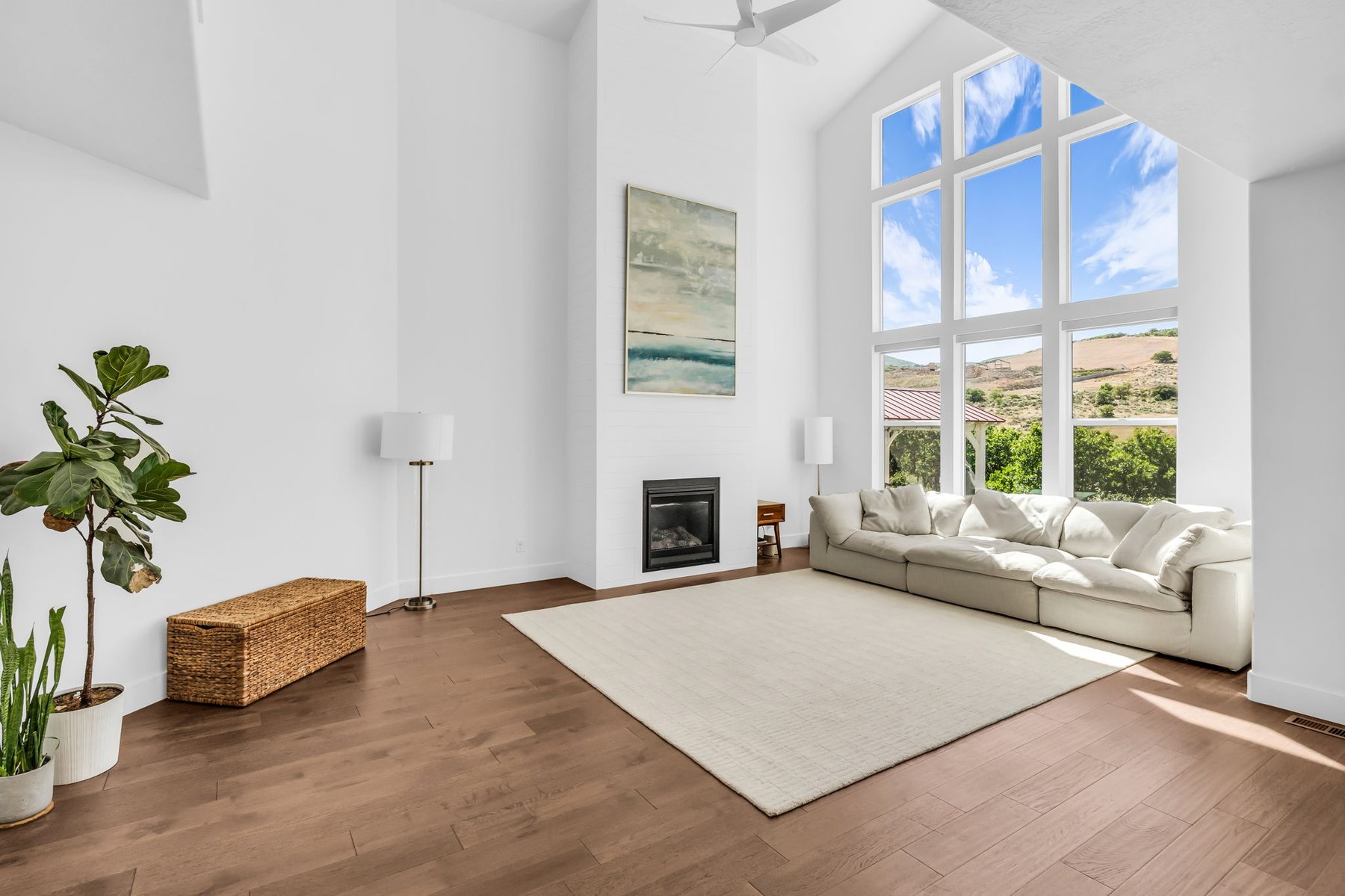 Vaulted great room at 12517 N Minots Ledge Dr Highland Utah with floor-to-ceiling windows and fireplace