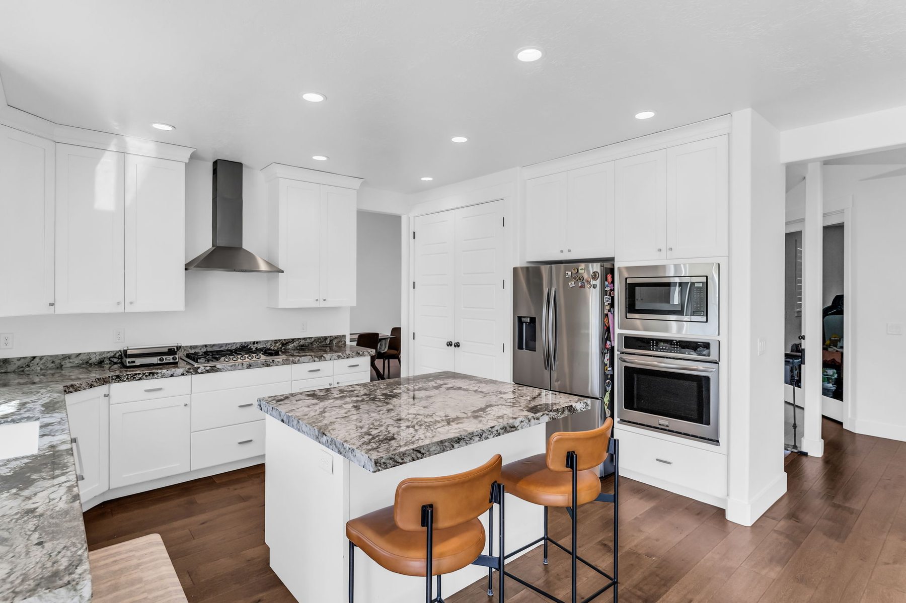 Kitchen at 12517 N Minots Ledge Dr with white shaker cabinets granite island and stainless appliances